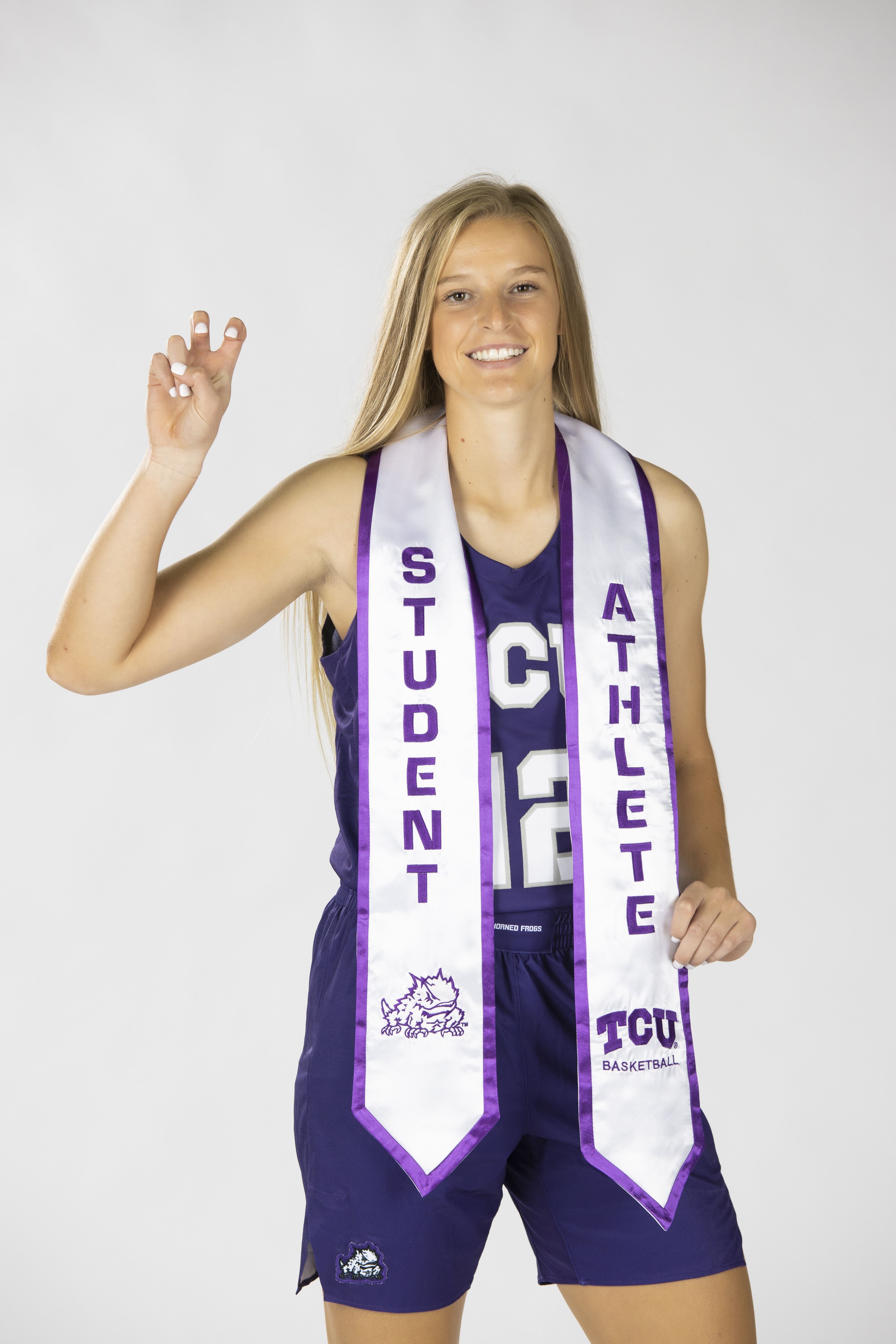 Emma Schmidt ’21 wearing a TCU basketball uniform and a white Student Athlete stole.