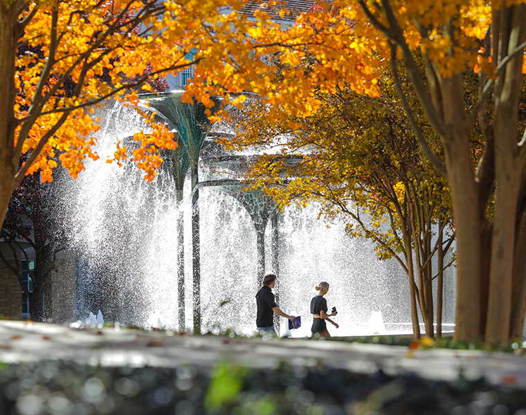 tcu students walking past frog fountain in the fall season