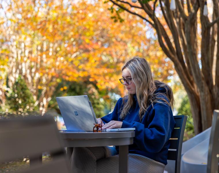 Female student on computer outside