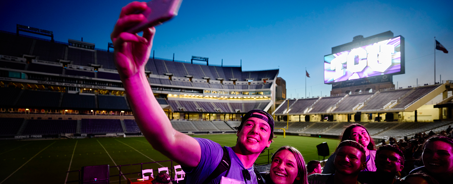 students taking a selfie at a football game