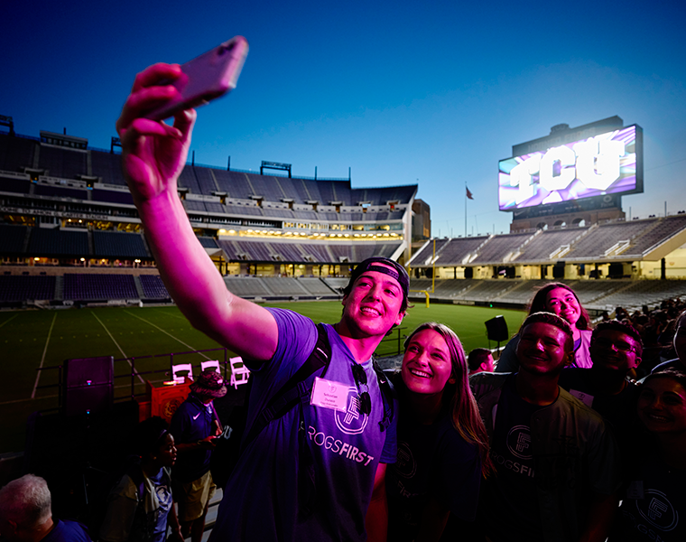 students taking a selfie at a football game