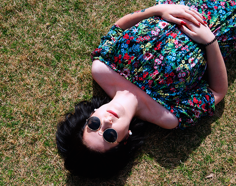 Female student relaxing while laying on the grass 