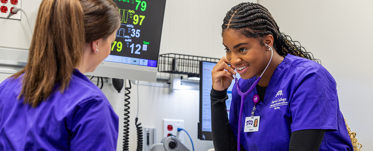 Two TCU nursing students working on a mock patient