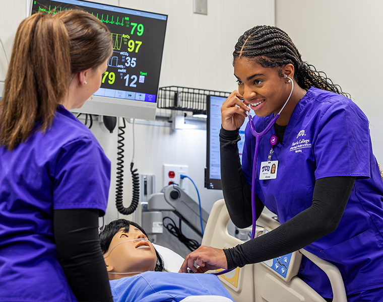 Two TCU nursing students working on a mock patient