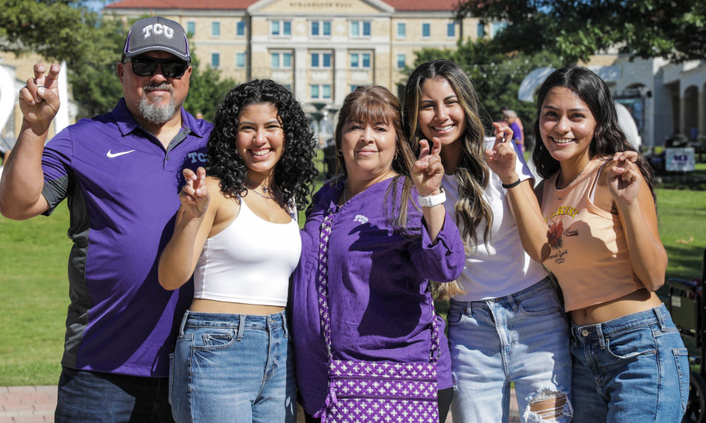 Family showing horned frog hand sign