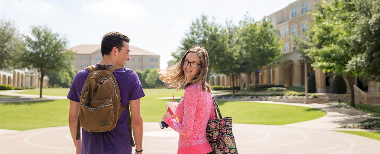 male and female student walking through the commons
