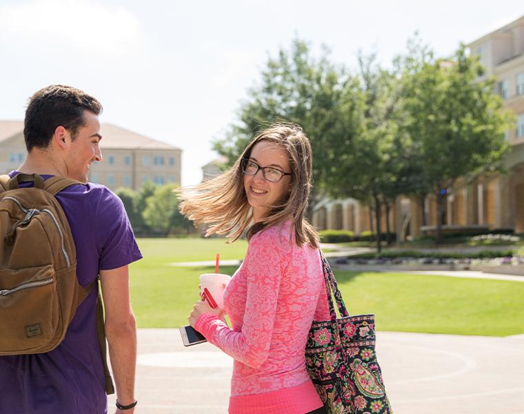 male and female student walking through the commons