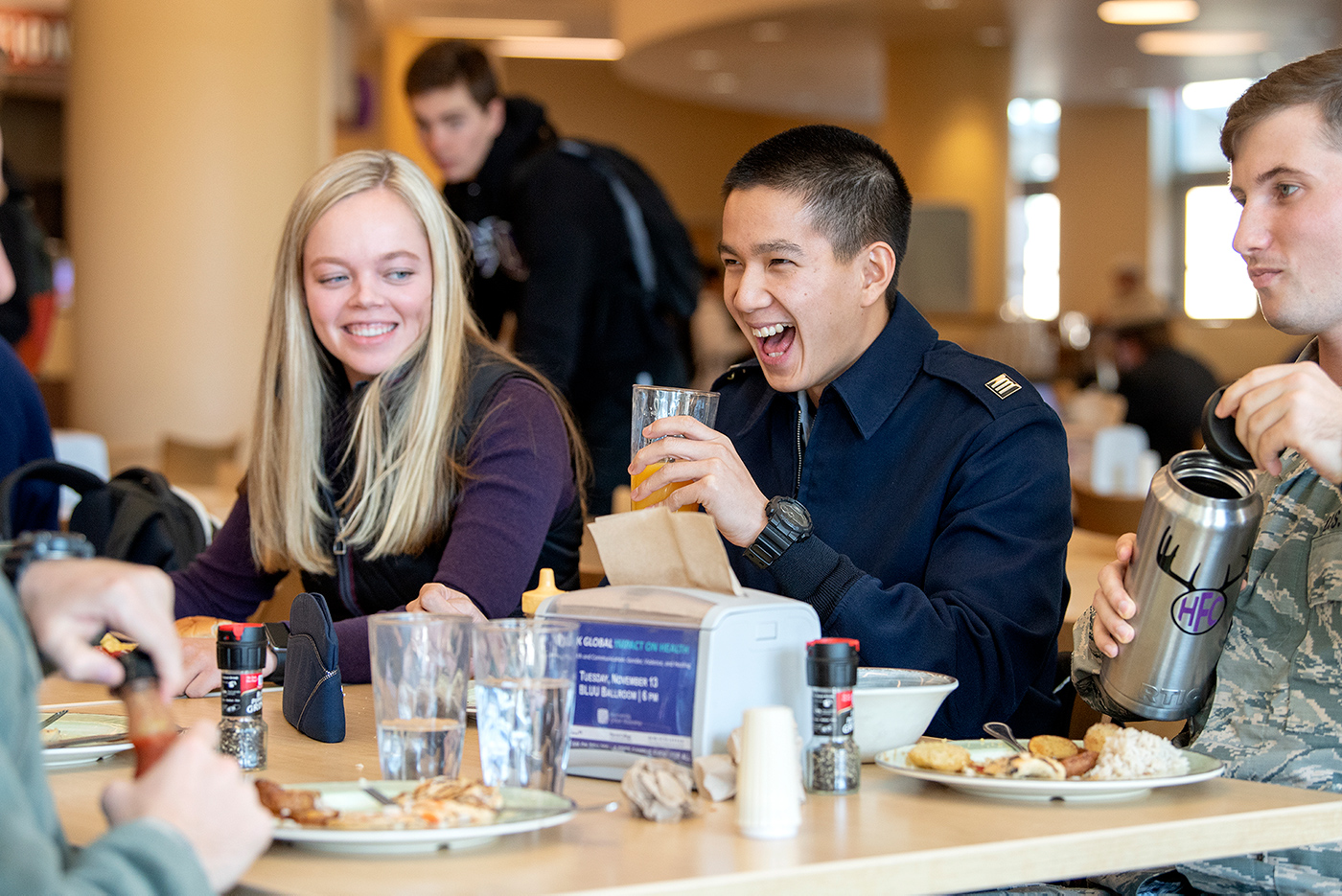 Male and female students eating at Market Square in the BLUU