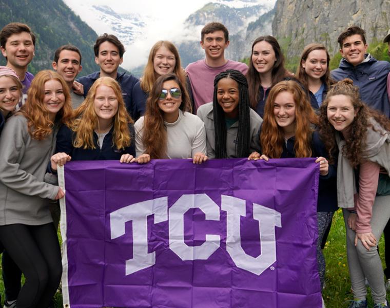 honors college students pose with a TCU flag while studying abroad 