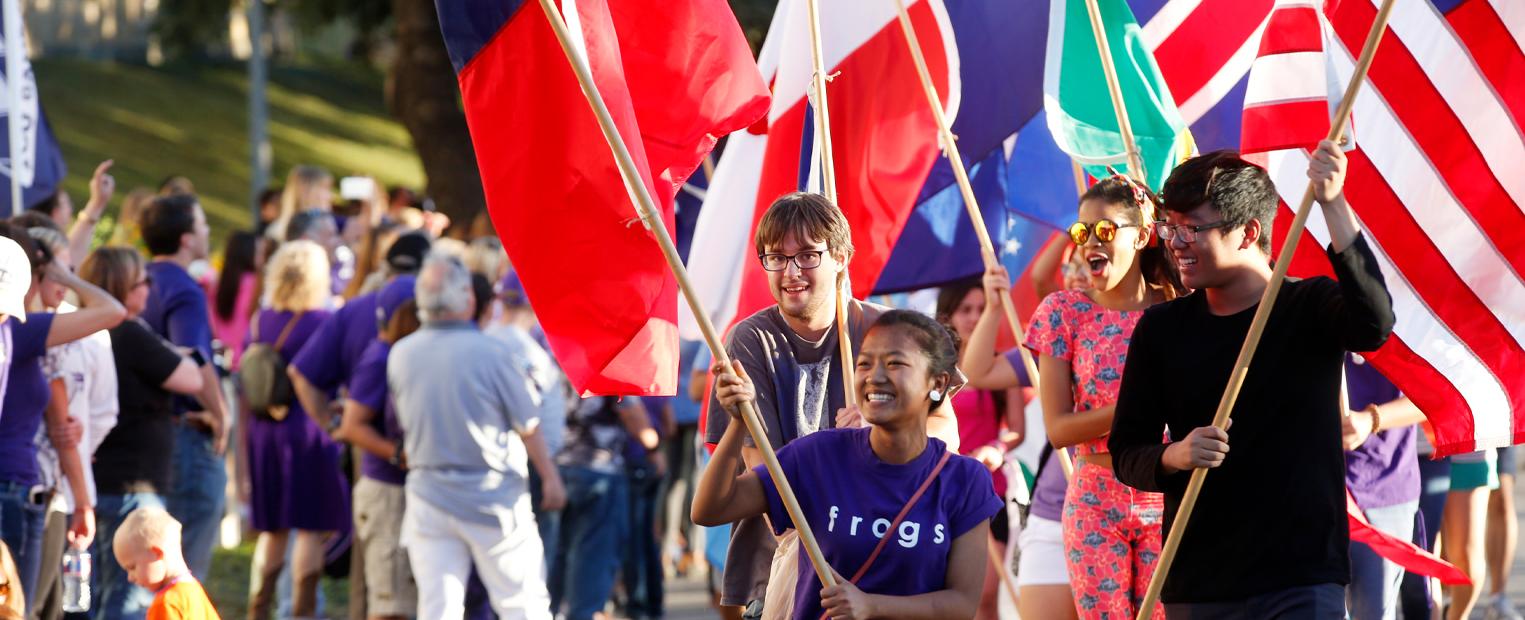 international students carrying flags at homecoming parade
