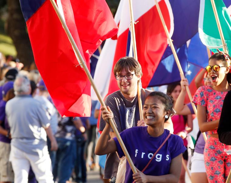 international students carrying flags at homecoming parade