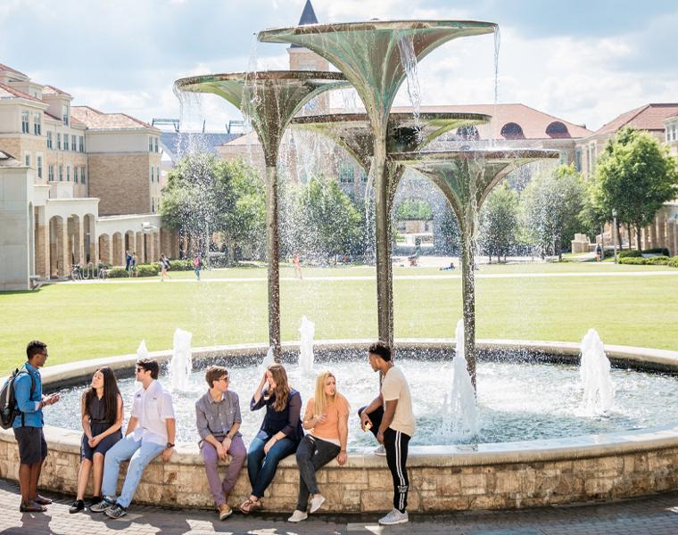 students hanging out near frog fountain