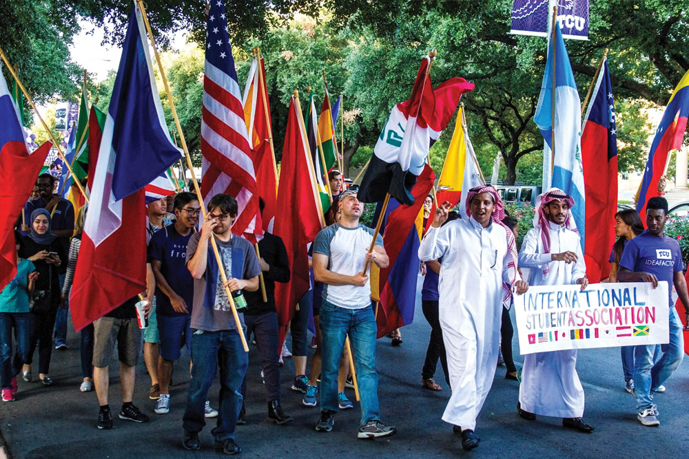 International students carry their flags during TCU's homecoming parade