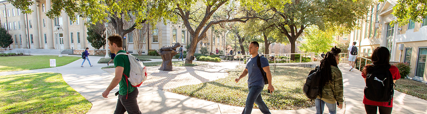Students walk around Frog Statue on their way to class