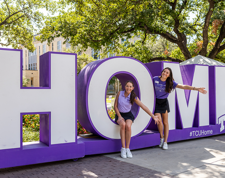 TCU Frog Home Sign with two students posing for a picture